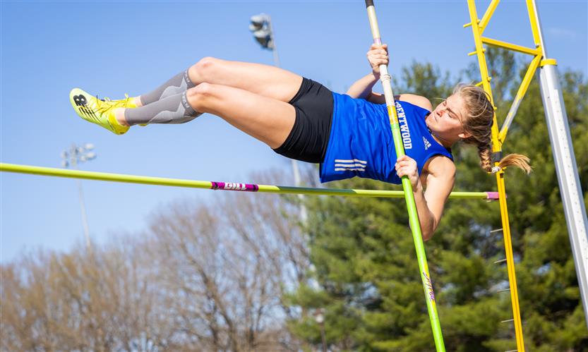A student jumps over the bar